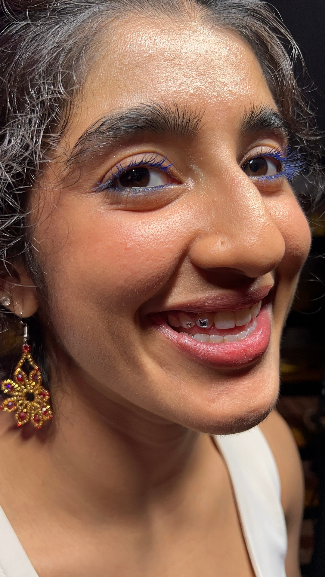 Client smiling with a crystal butterfly tooth gem